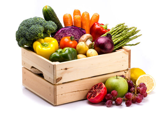 Pine box full of colorful fresh vegetables and fruits on a white background