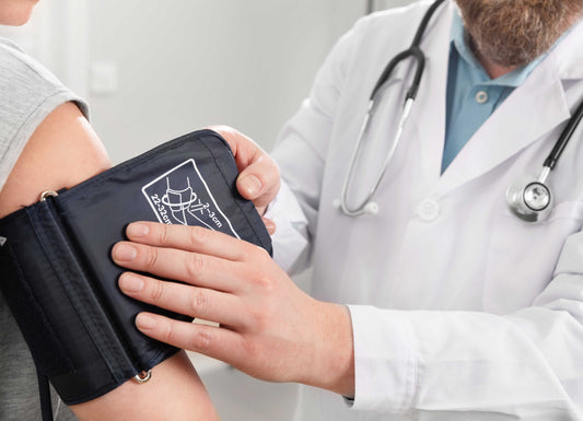 A zoomed-in picture of a doctor placing a blood pressure band on a person's arm. High Blood Pressure