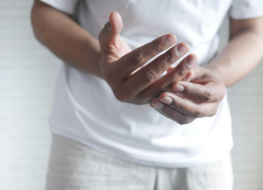 Depicted is a close up of someone's hands as they examine the Right hand with their left. Neuropathy