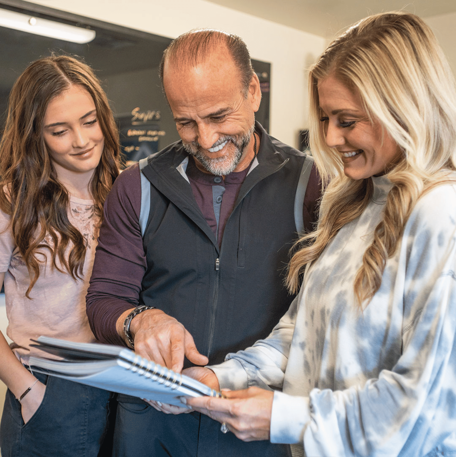 Image of Hilary and Doug looking over fitness plans with a client.